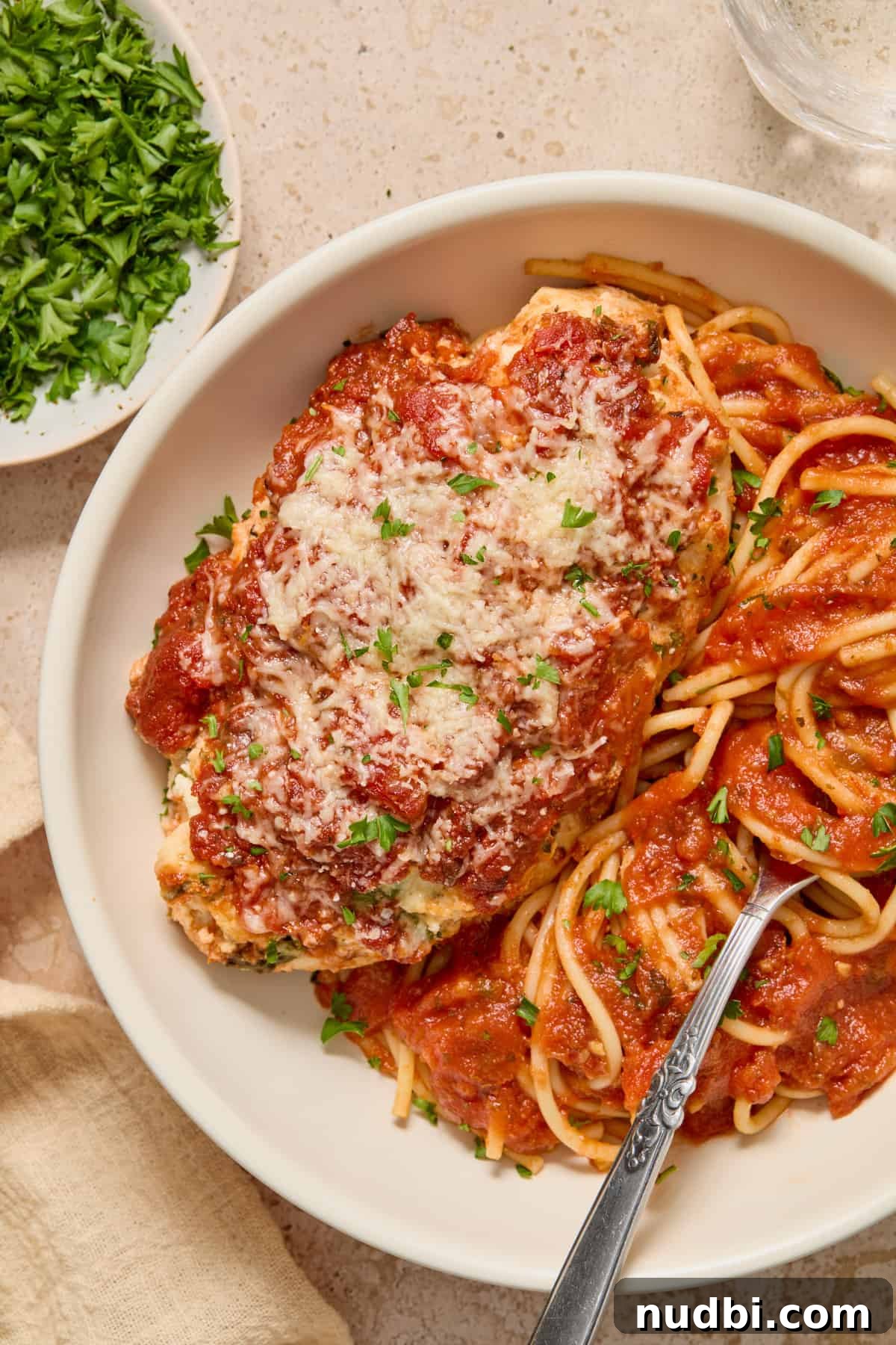 Spinach and Ricotta Stuffed Chicken Breast Recipe 10 Baked chicken in bowl of spaghetti with fork.
