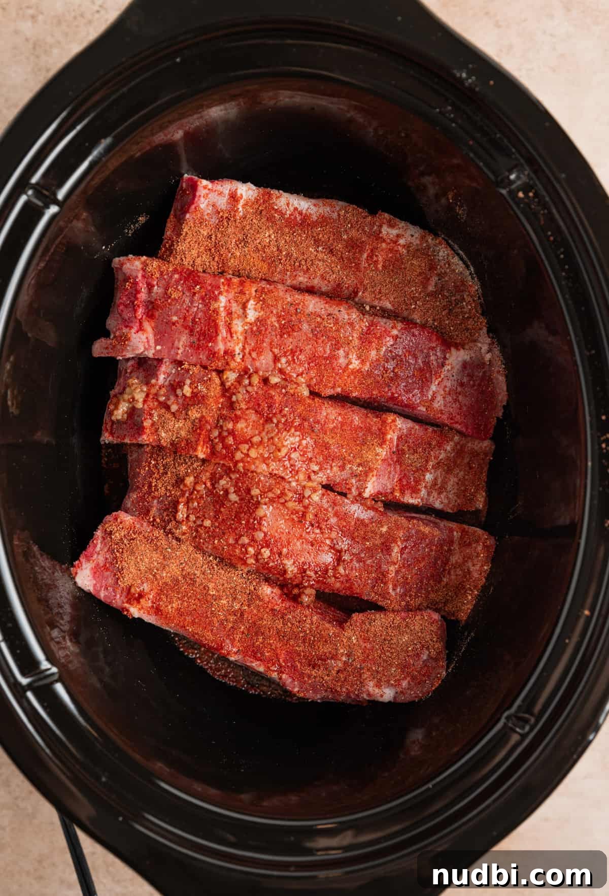 Slow-Cooker Country-Style BBQ Ribs: Tender, Fall-Off-the-Bone Recipe 6 Country style boneless pork ribs lined in crockpot with seasoning over top.
