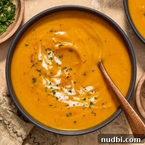 Maple-Roasted Sweet Potato and Carrot Soup Recipe 6 Bowl of carrot sweet potato soup with spoon.