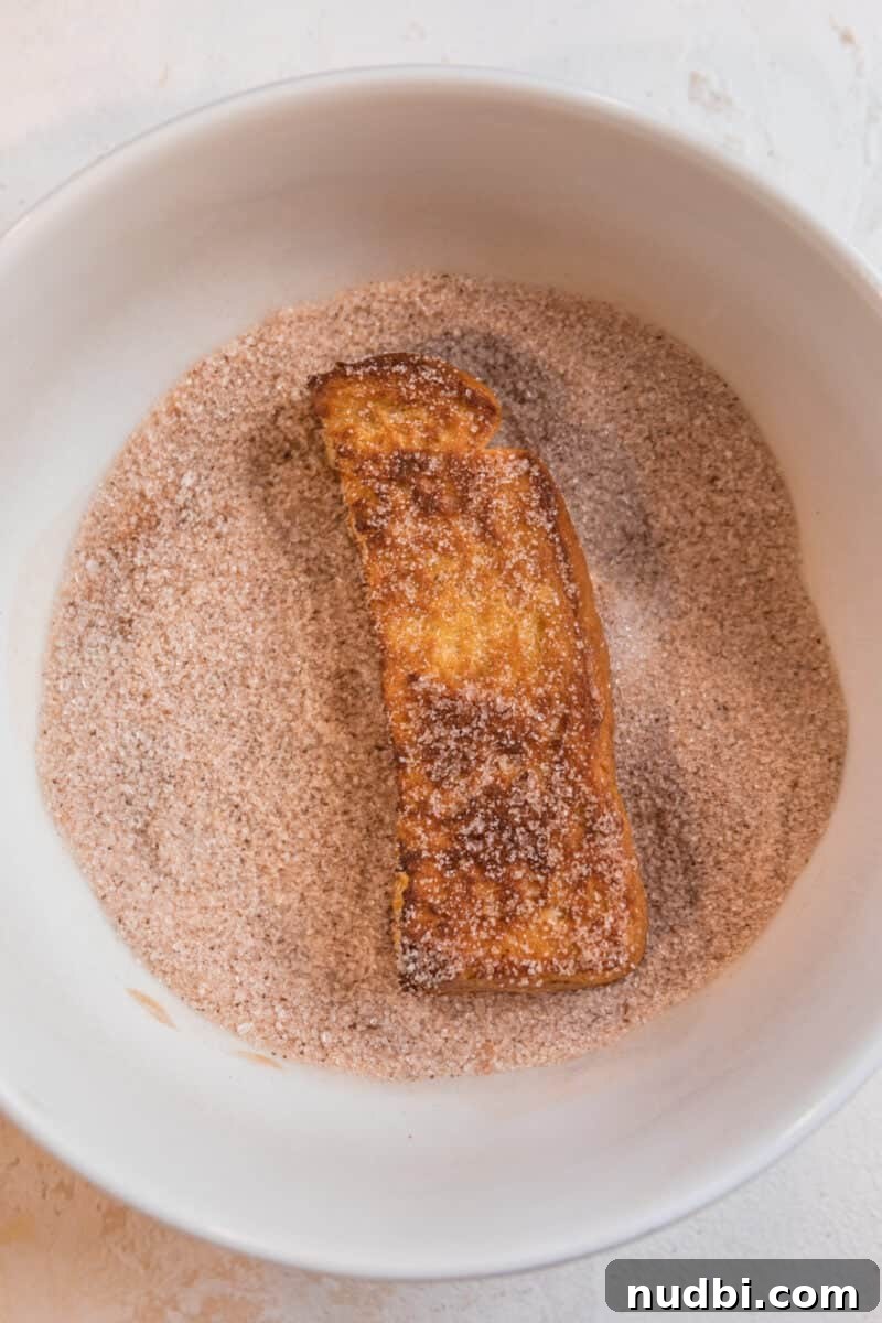 Crispy Air Fryer French Toast Sticks Recipe 8 Air fried French toast stick in dish with cinnamon sugar coating.