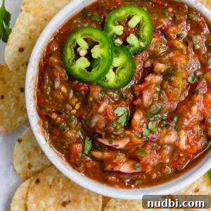 Smoky Roasted Tomato Salsa Recipe for Fresh Homemade Salsa 8 Overhead shot of bowl of salsa with chips and jalapeños.