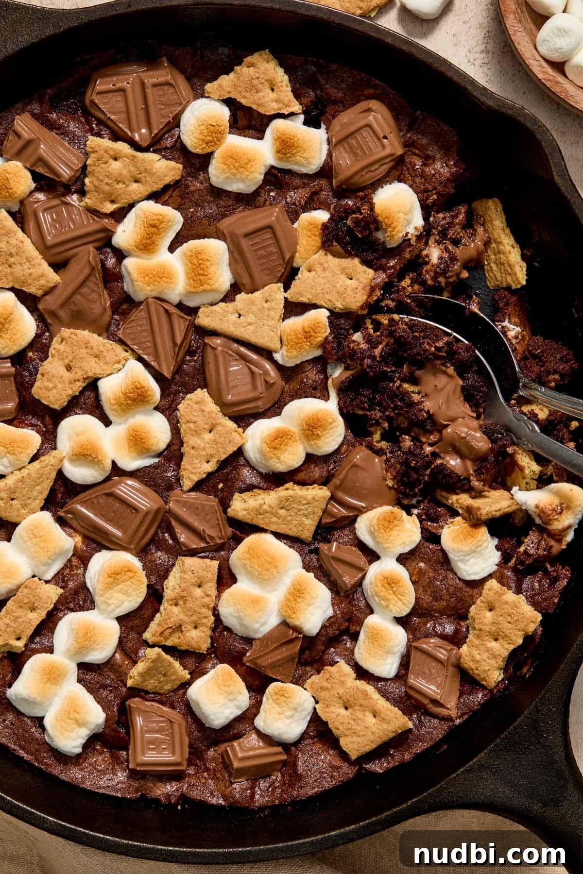Skillet S'mores Brownie Recipe: Gooey Campfire Dessert 2 S'mores brownie in skillet with two spoons scooping into the brownie.