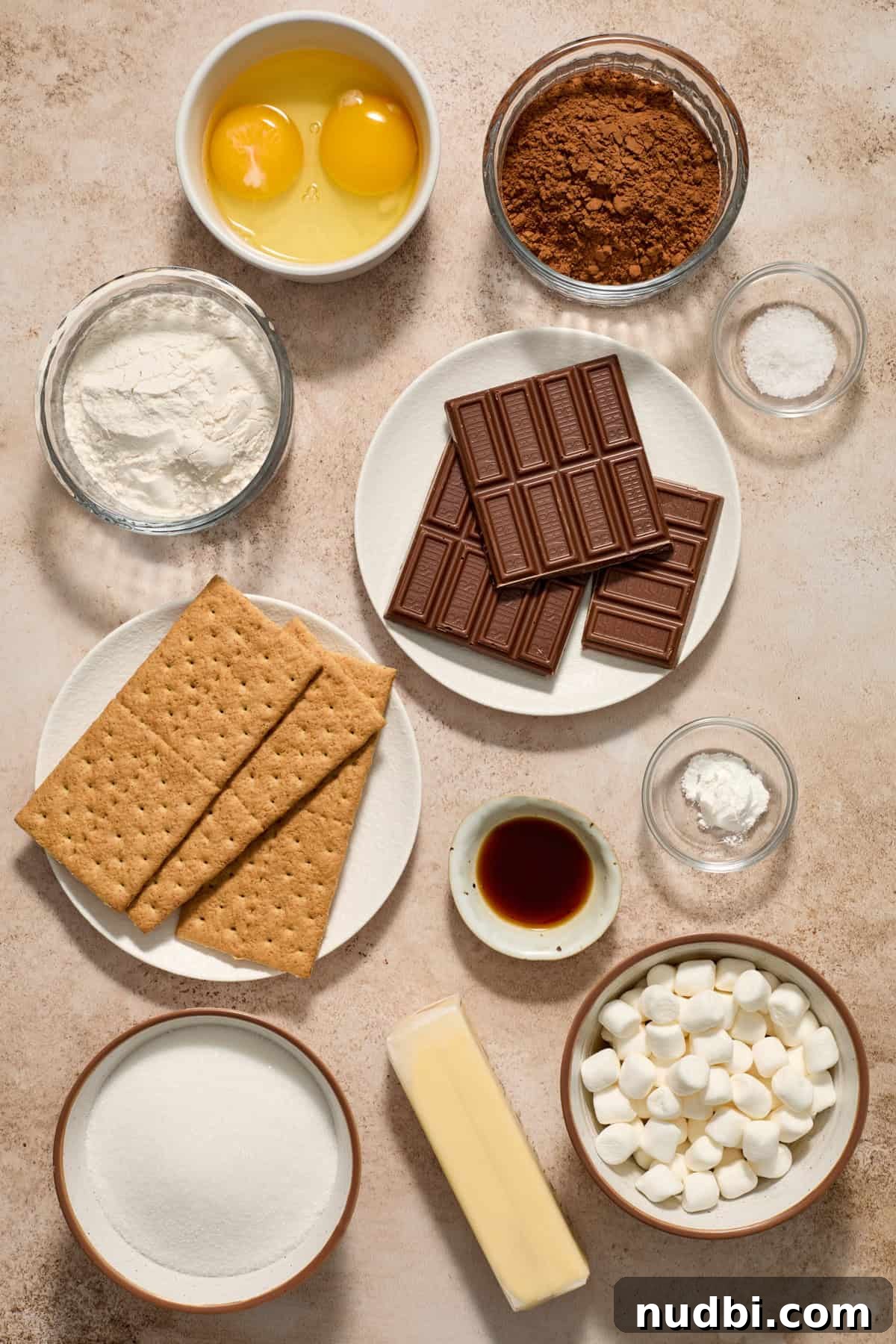 Skillet S'mores Brownie Recipe: Gooey Campfire Dessert 3 Eggs, sugar, chocolate bars, butter and other ingredients arranged on surface.