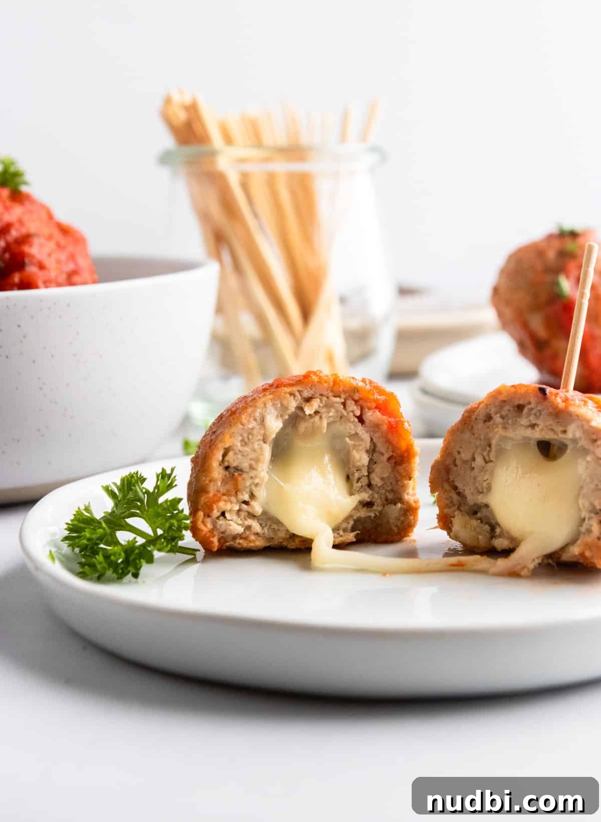 Mozzarella-Stuffed Turkey Meatballs Recipe for Juicy Bites 2 Mozzarella stuffed meatballs on plate.