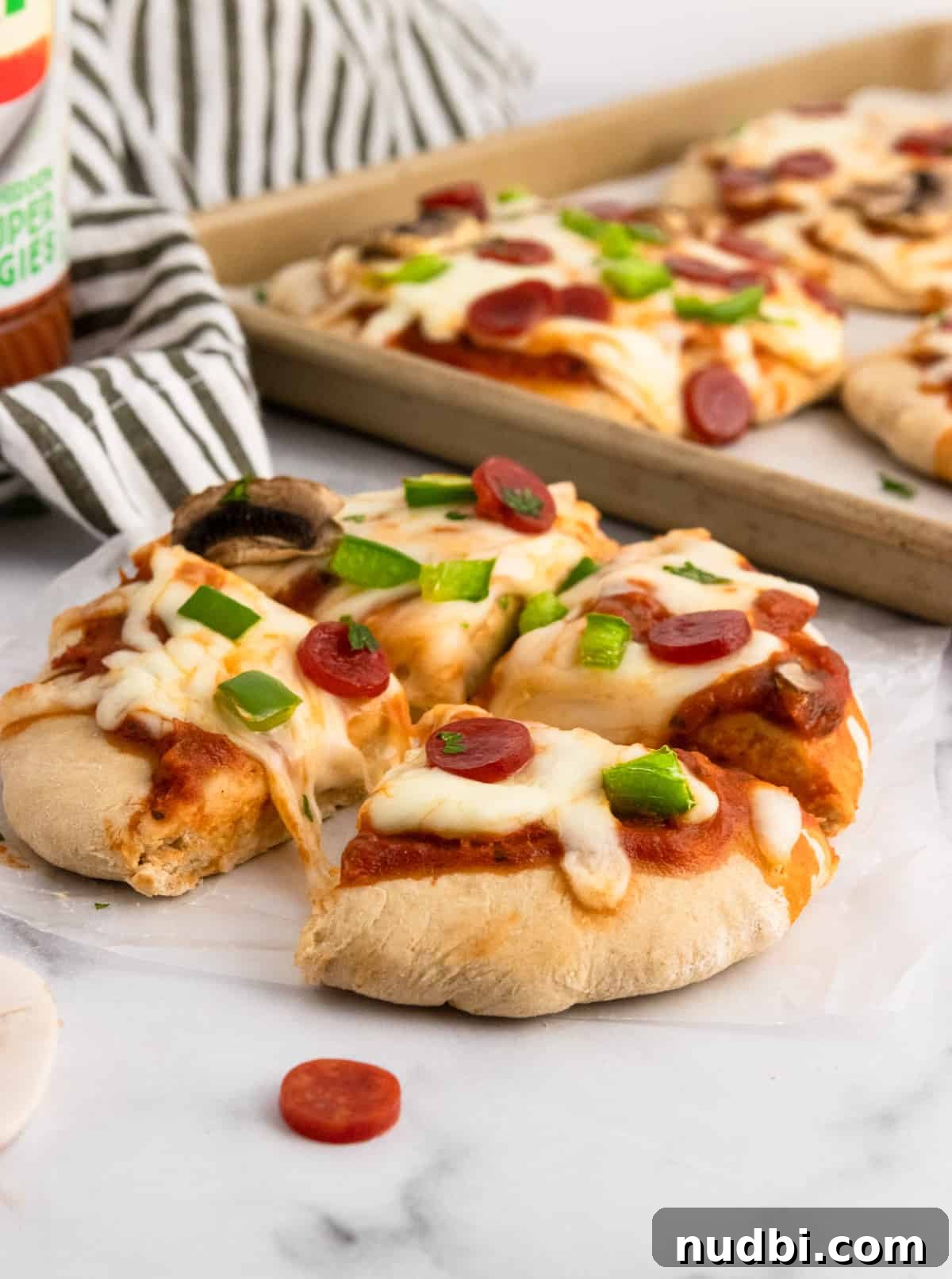 Whole Wheat Mini Veggie-Packed Pizzas for Kids 3 Pizza cut into fourths with pan in background.