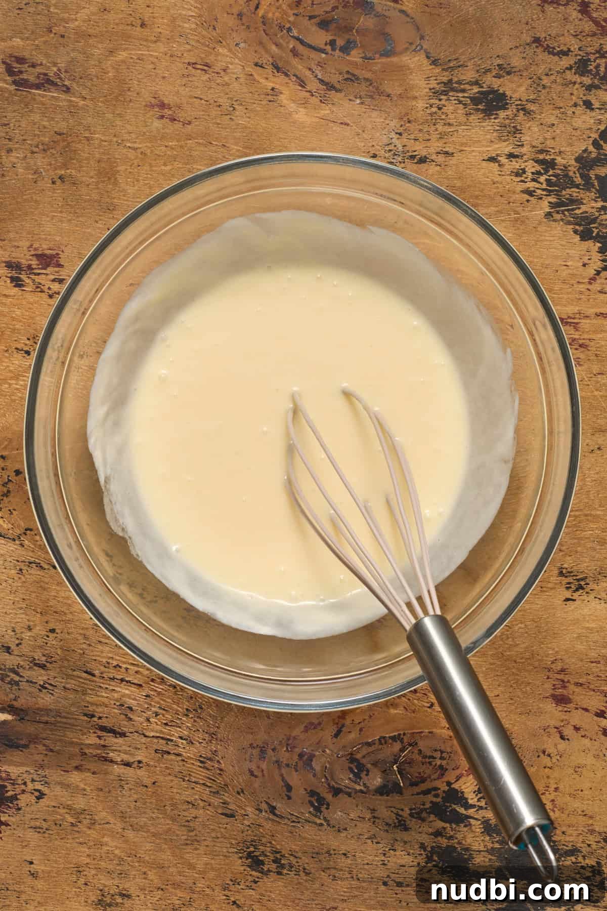 Sweet Honey Cornbread Casserole Recipe for Comforting Family Meals 6 Egg, honey, sour cream and butter whisked in glass bowl.