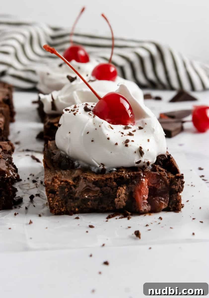 Decadent Dark Chocolate Cherry Brownie Recipe 2 Cherry brownies with whipped cream and cherry on top.