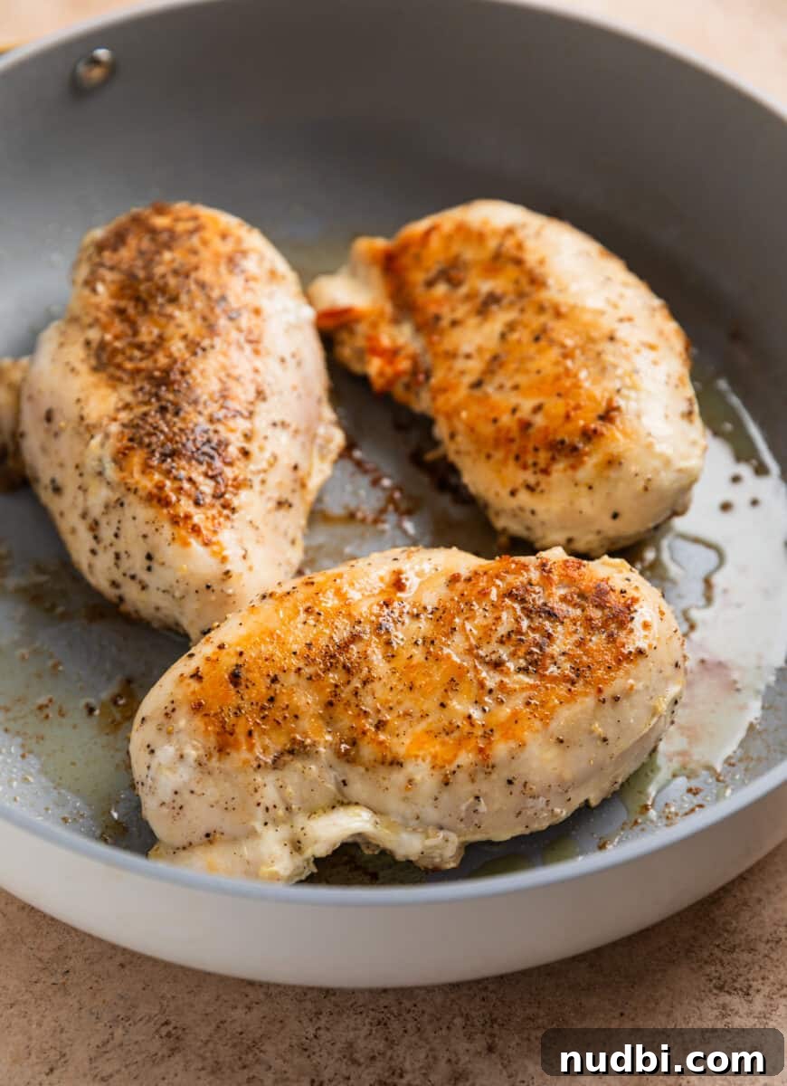 Simple White Wine Chicken Recipe for Weeknight Dinners 4 Chicken breasts seared in skillet with olive oil.
