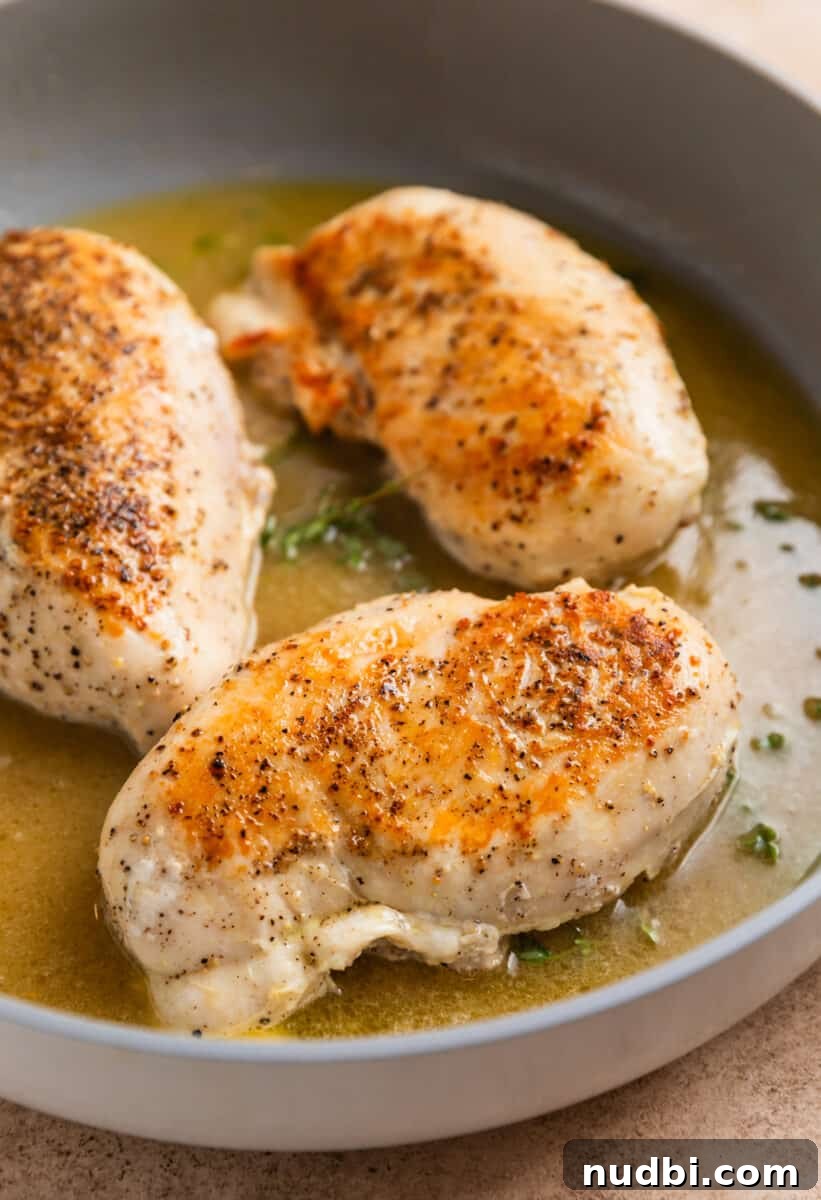 Simple White Wine Chicken Recipe for Weeknight Dinners 5 White wine, chicken broth, fresh thyme and butter in skillet with chicken breast that has been seared on both sides.