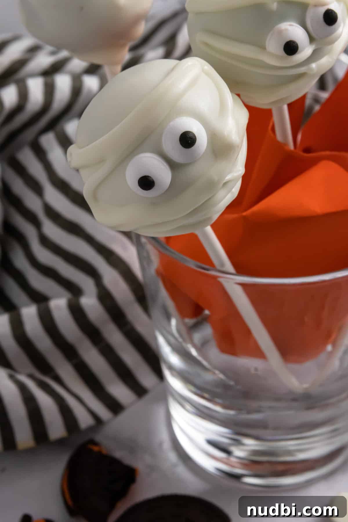 Spooky Halloween Cake Pop Ideas for Parties and Treats 2 Halloween cake pops in glass cup.