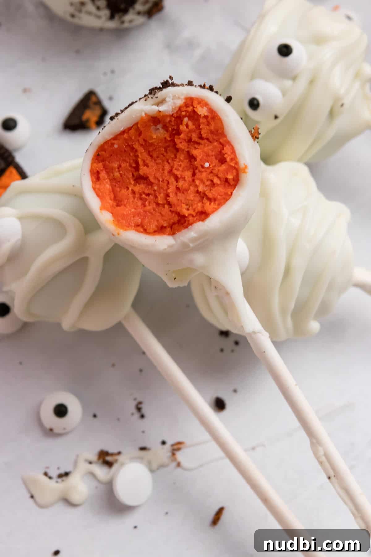 Spooky Halloween Cake Pop Ideas for Parties and Treats 9 Cake pop with bite taken out to show orange inside.