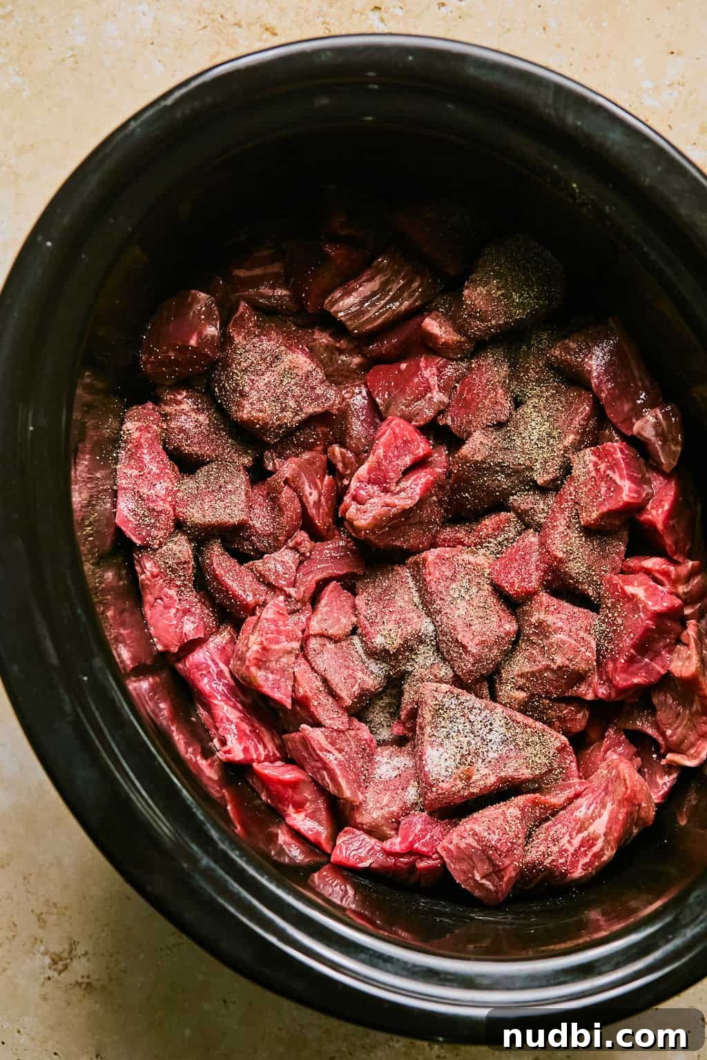 Slow Cooker Beef Brisket Chili Recipe for Tender, Smoky Flavor 4 Crock pot filled with cubed beef and seasoning.
