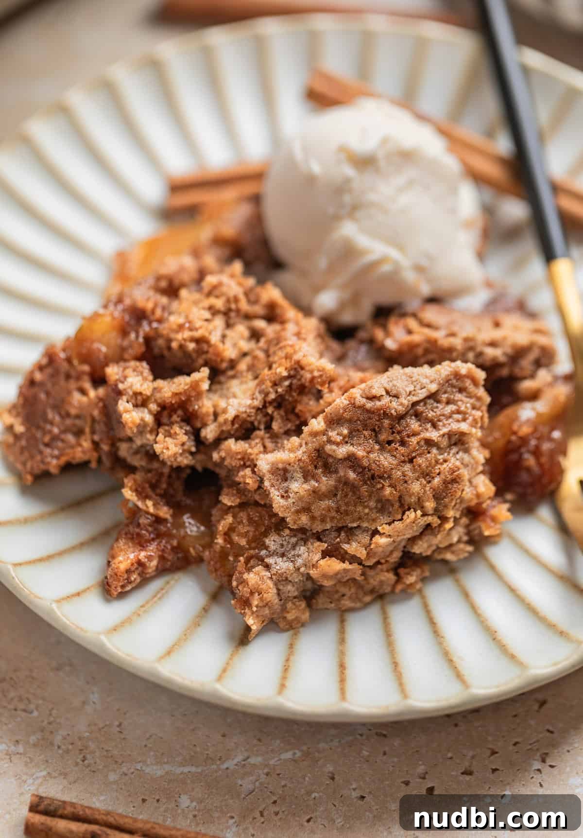 Classic Apple Dump Cake Recipe: Quick Homemade Comfort Dessert 2 Apple dump cake served on dish with fork and scoop of vanilla ice cream.