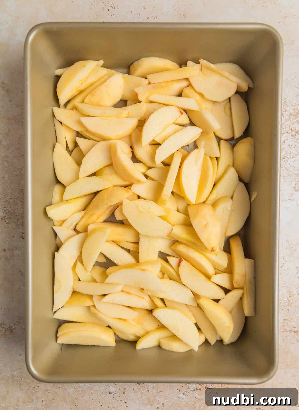 Classic Apple Dump Cake Recipe: Quick Homemade Comfort Dessert 4 Peeled, sliced apples in baking pan.