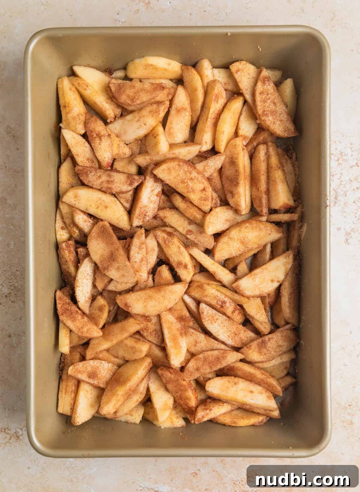 Classic Apple Dump Cake Recipe: Quick Homemade Comfort Dessert 6 Cinnamon sugar coated apples in baking pan.