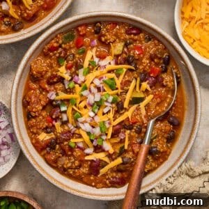 Hearty Pumpkin Quinoa Chili Recipe for Fall Nights 4 Bowl of chili with quinoa, pumpkin, beans and spoon scooping in.