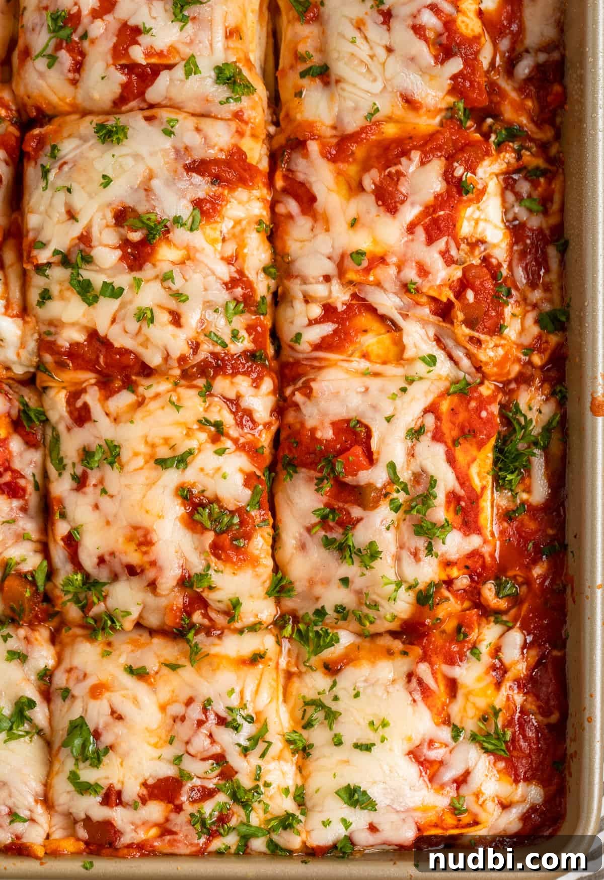 No-Boil Lasagna Recipe: Quick, Cheesy Oven-Baked Lasagna 2 Easy no boil lasagna in pan sliced into squares and topped with chopped parsley.