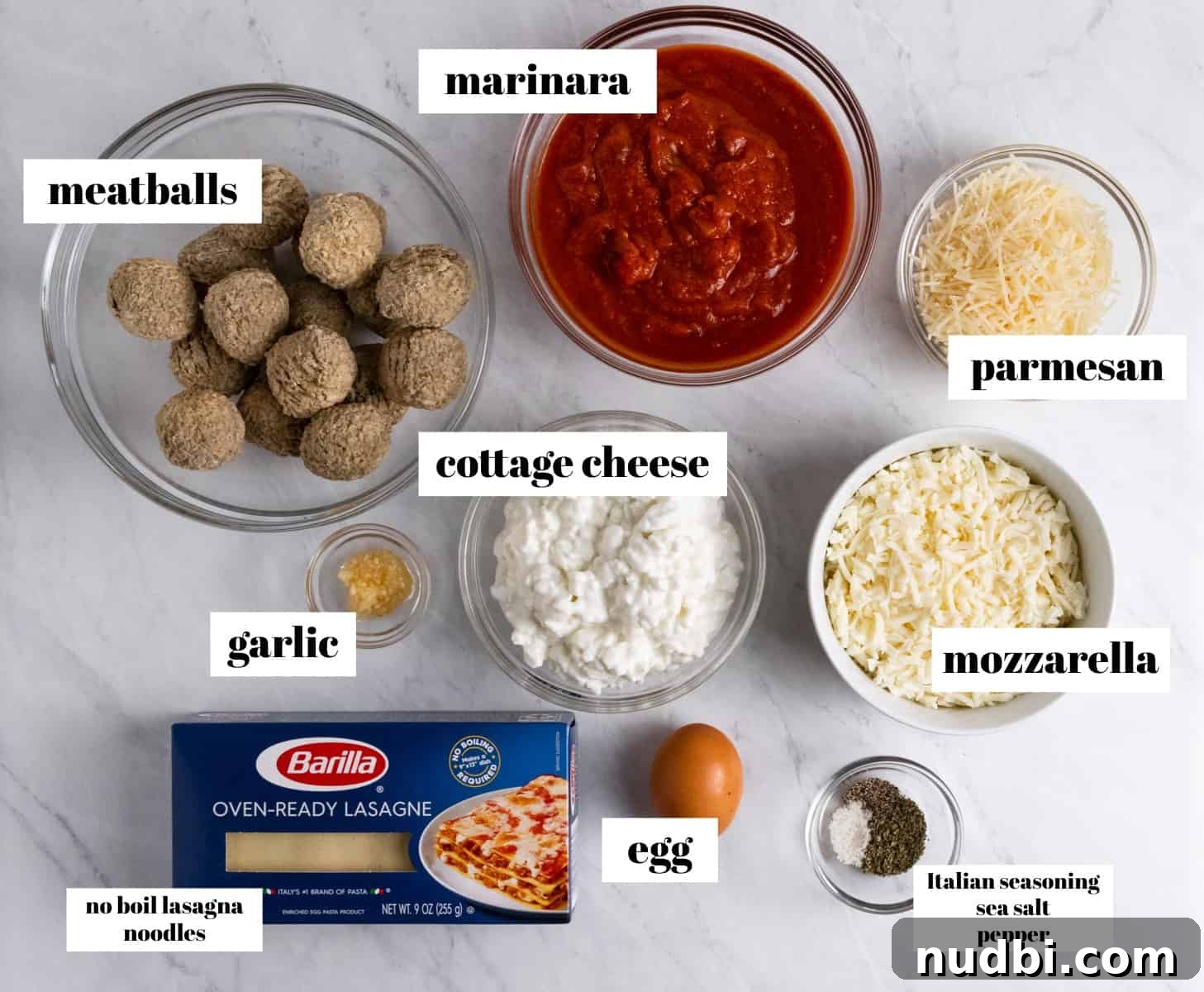 No-Boil Lasagna Recipe: Quick, Cheesy Oven-Baked Lasagna 3 Lasagna ingredients labeled on counter including cheese, noodles, meatballs and more.