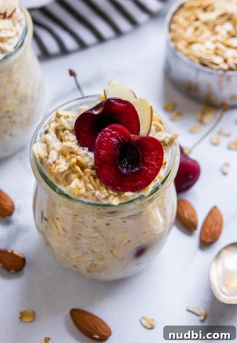 Creamy Vegan Overnight Oats Recipe for Quick Plant-Based Breakfast 4 Vegan overnight oats in jars with cherries on top.