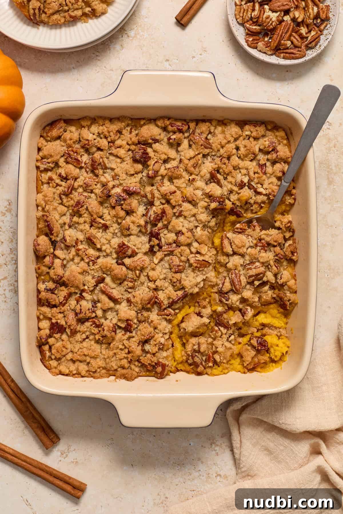Creamy Butternut Squash Casserole with Sage and Parmesan 2 Butternut squash casserole in baking pan with serving spoon scooping into it.