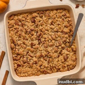 Creamy Butternut Squash Casserole with Sage and Parmesan 10 Square baking pan with butternut squash casserole topped with pecan crumble.
