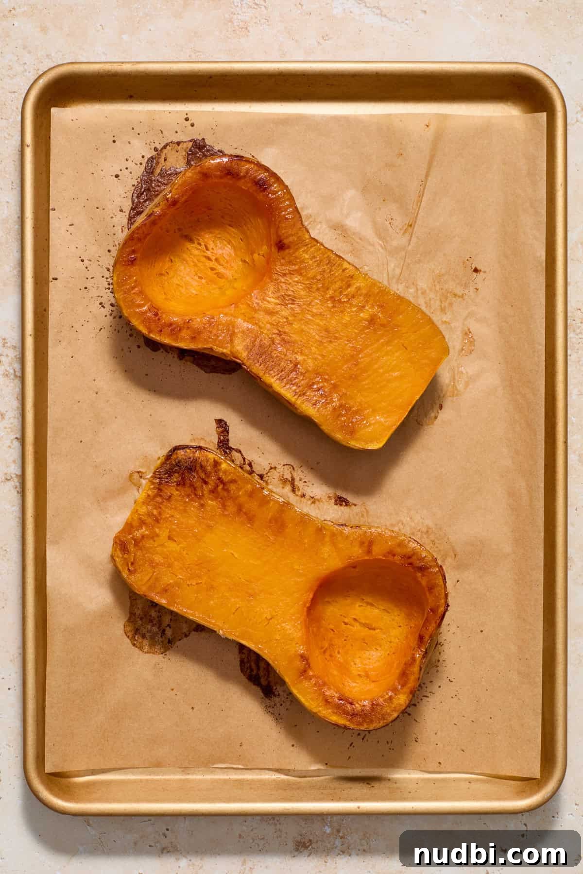 Creamy Butternut Squash Casserole with Sage and Parmesan 4 Baked butternut squash on parchment lined baking sheet.