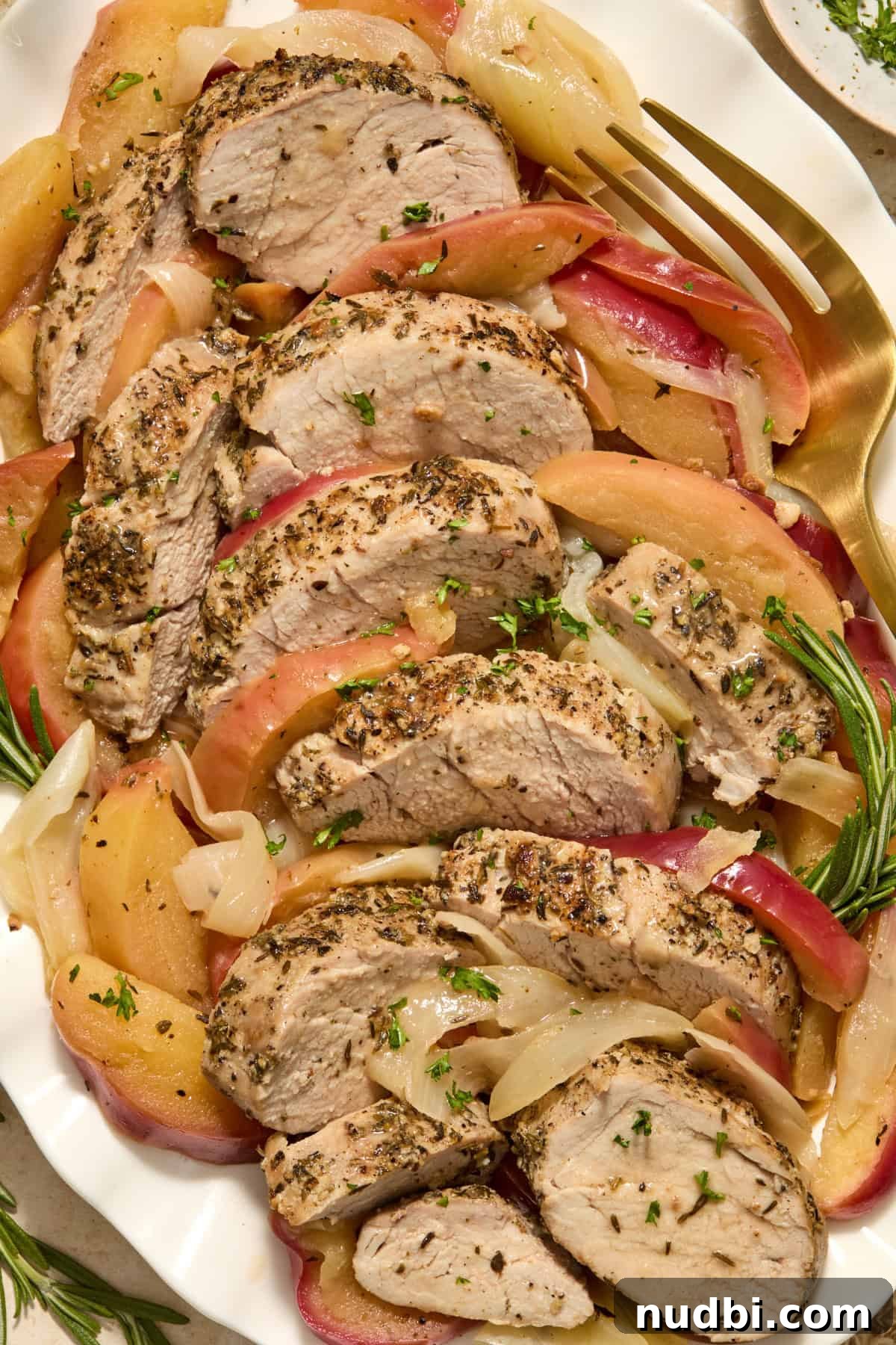 Juicy Instant Pot Pork Tenderloin Recipe for Quick Dinners 13 Sliced pork on serving platter with cooked apples and onions.