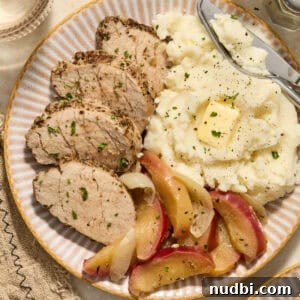 Juicy Instant Pot Pork Tenderloin Recipe for Quick Dinners 14 Pork tenderloin sliced on plate with apples and mashed potatoes.