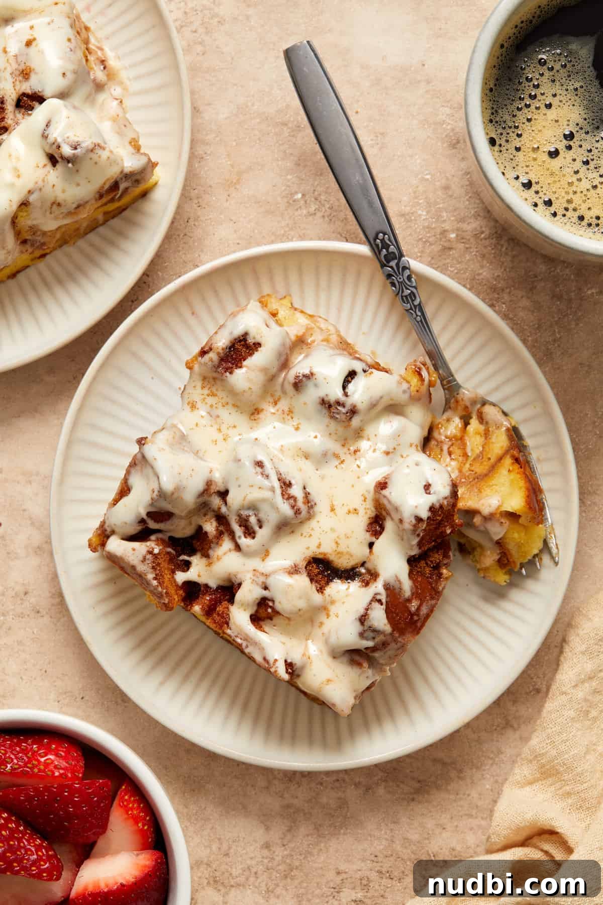 Cinnamon Roll Baked French Toast Recipe for Brunch 13 French toast bake slice on pie plate with forkful off to the side.