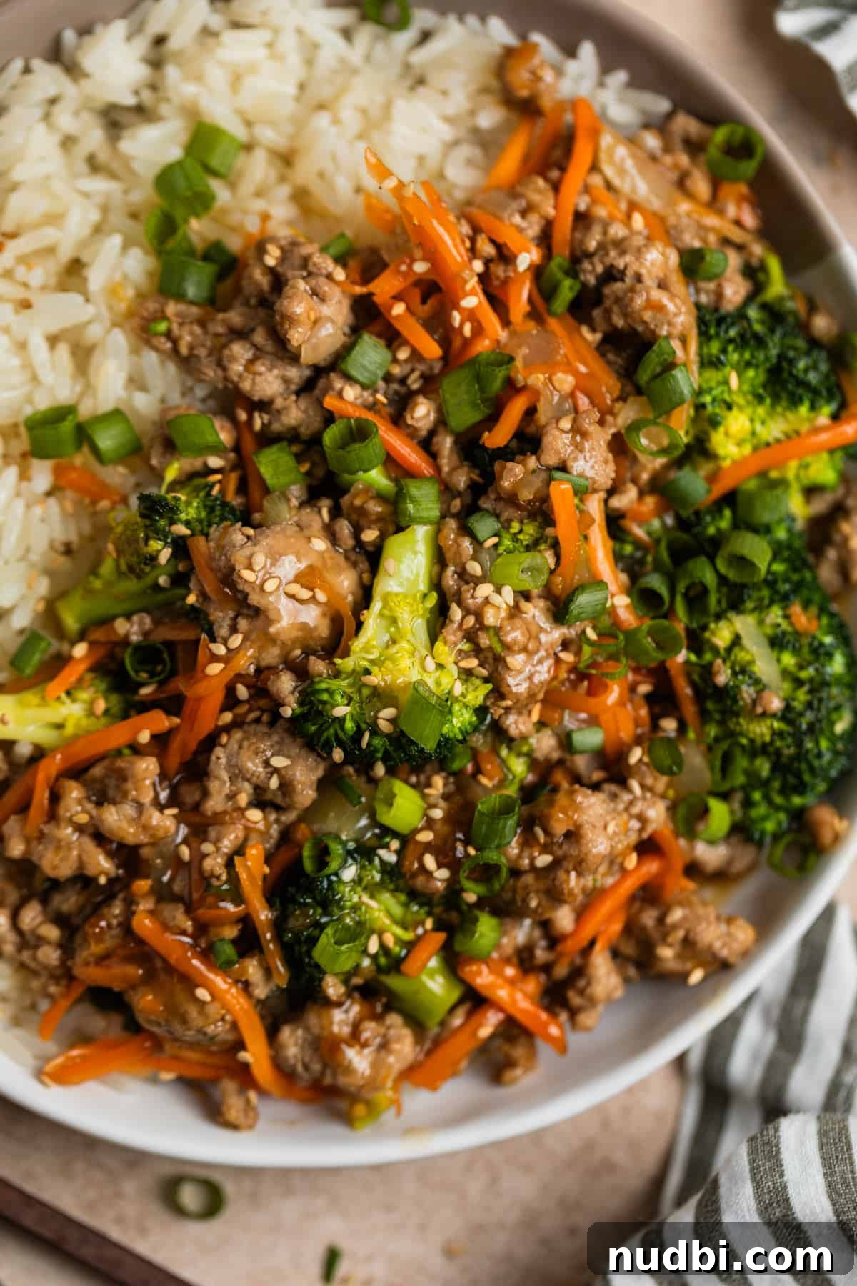 Teriyaki Ground Turkey Stir-Fry with Veggies and Rice 2 Ground turkey teriyaki stir fry with rice in bowl topped with green onion and sesame seeds.