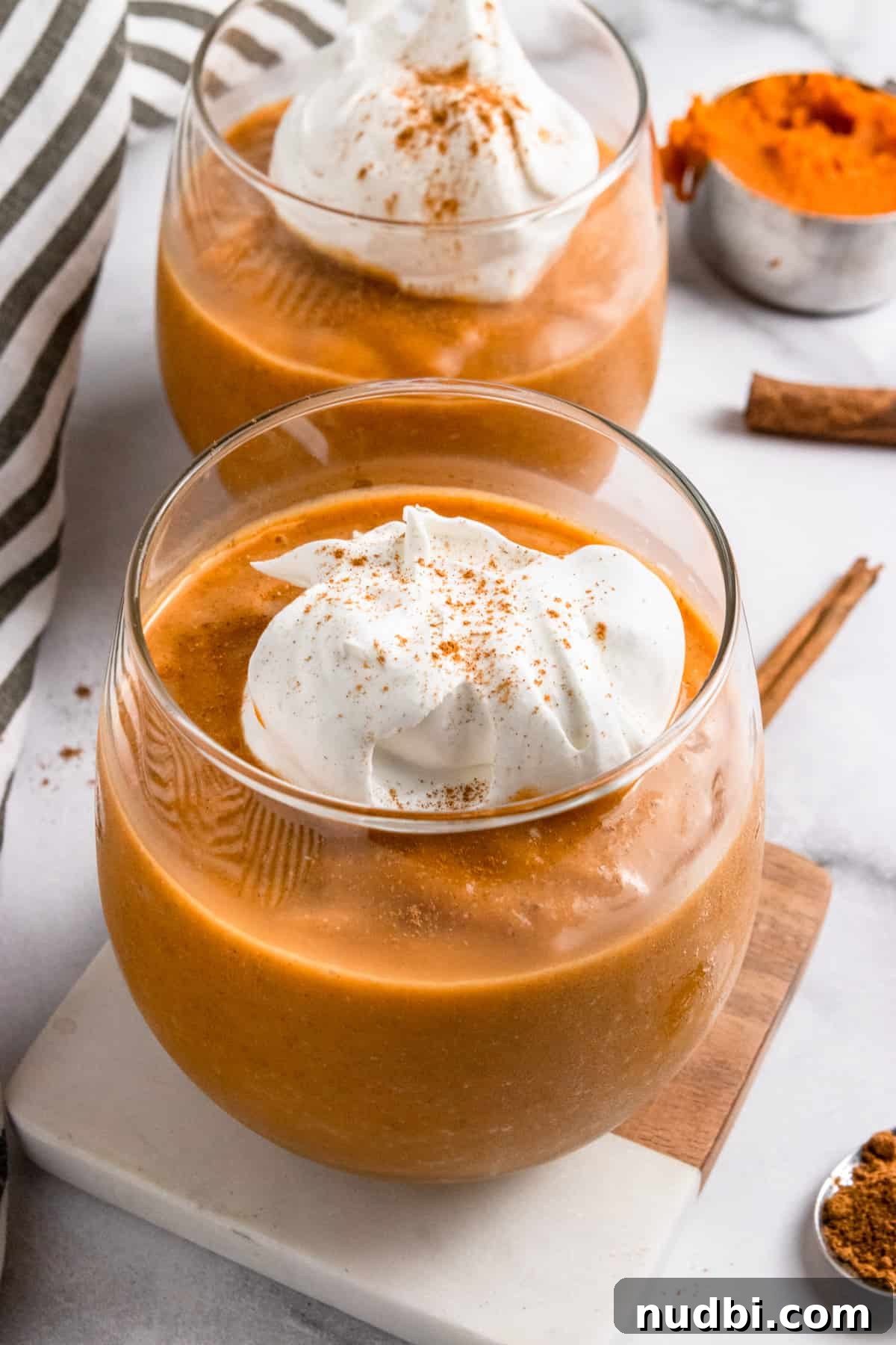 Pumpkin Pie Smoothie Recipe for Creamy Fall Breakfast 2 Pumpkin smoothie in glass with whipped cream on top.
