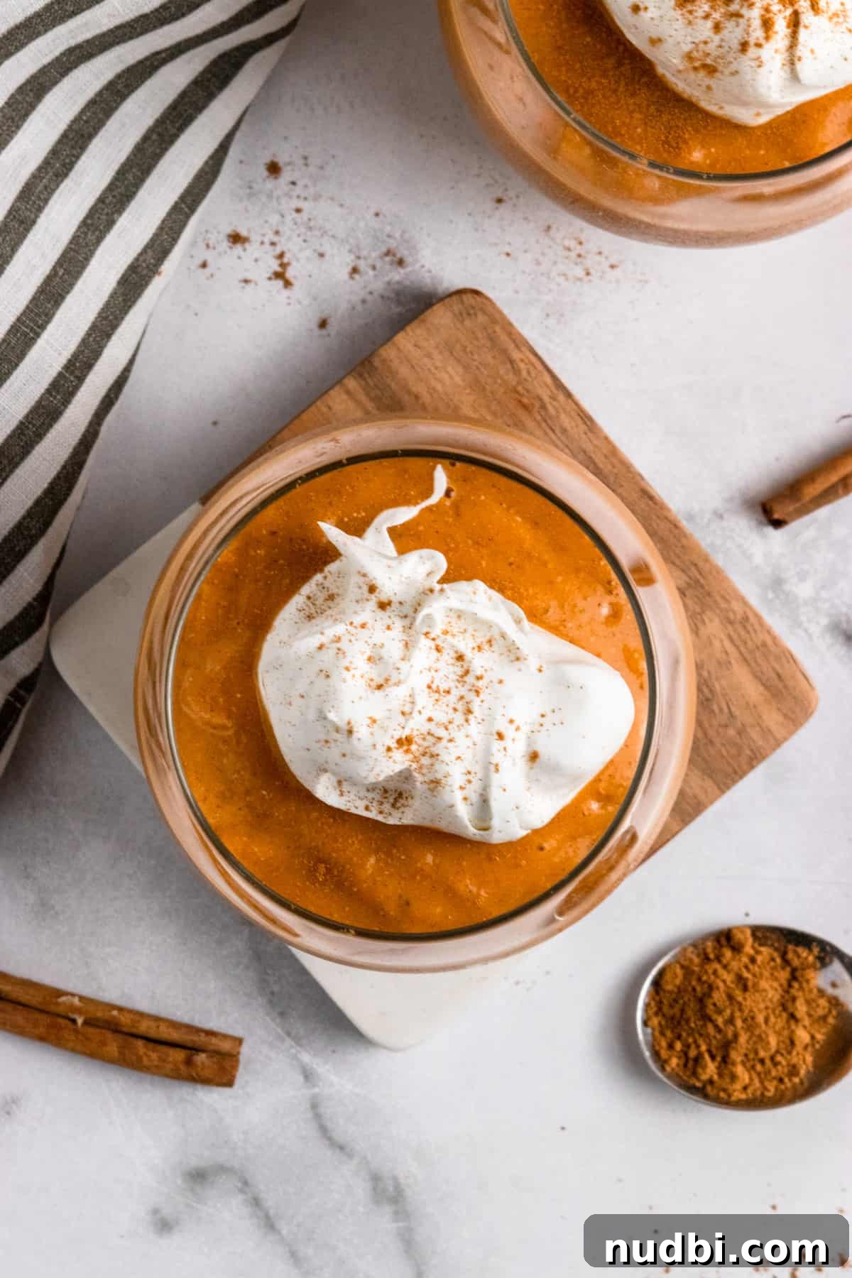 Pumpkin Pie Smoothie Recipe for Creamy Fall Breakfast 3 Overhead view of pumpkin smoothie in glass with whipped cream.