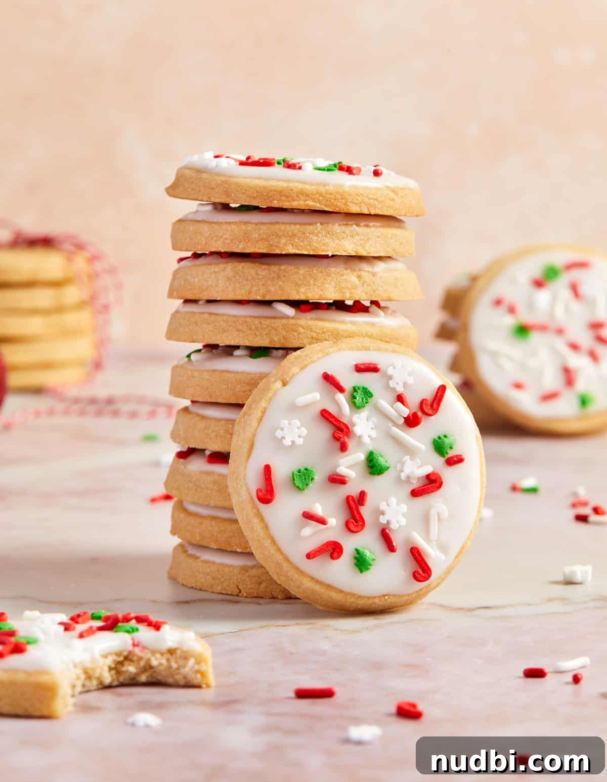 Classic Christmas Shortbread Cookies Recipe for the Holidays 13 Stack of iced brown sugar Christmas shortbread cookies with one cookie propped up against the stack.