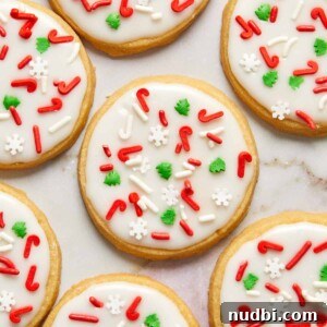 Classic Christmas Shortbread Cookies Recipe for the Holidays 14 Iced shortbread cookies with Christmas sprinkles arranged on counter.