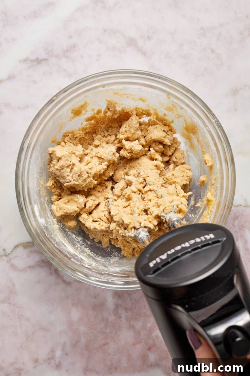 Classic Christmas Shortbread Cookies Recipe for the Holidays 6 Flour added and mixed into glass bowl with butter and sugar.