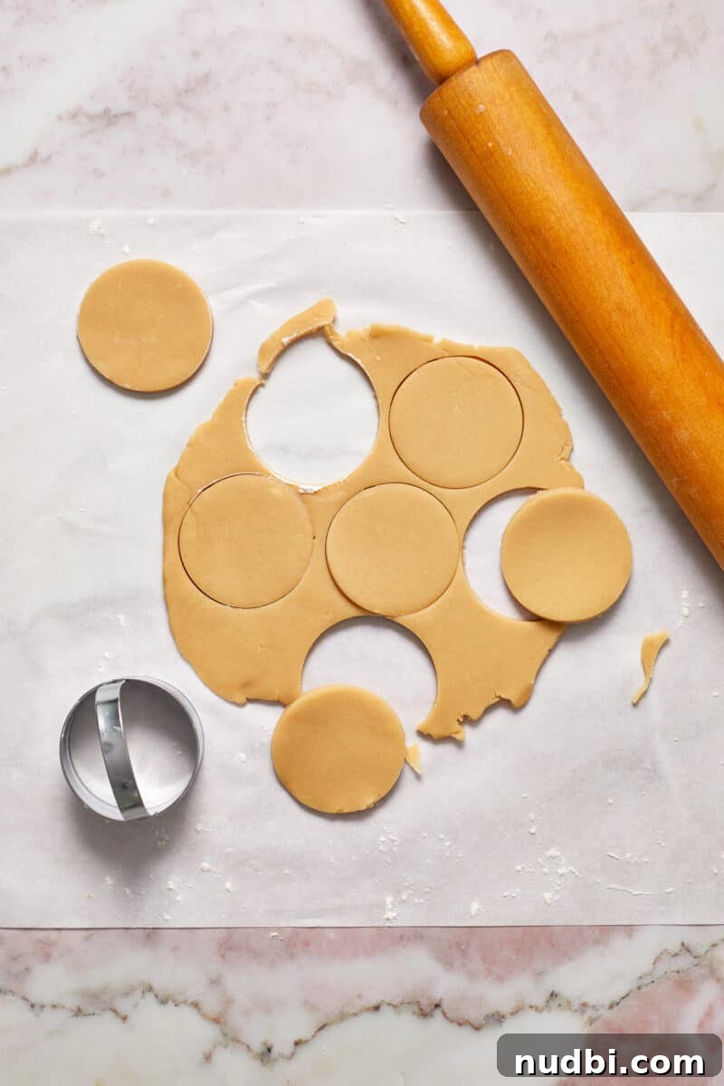 Classic Christmas Shortbread Cookies Recipe for the Holidays 9 Rolled shortbread cookie dough on parchment with cookie cutter and rolling pin.
