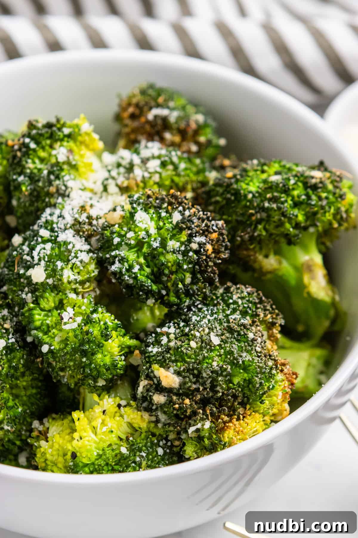 Crispy Air Fryer Broccoli with Garlic and Parmesan 2 Air fryer broccoli in white bowl with parmesan.