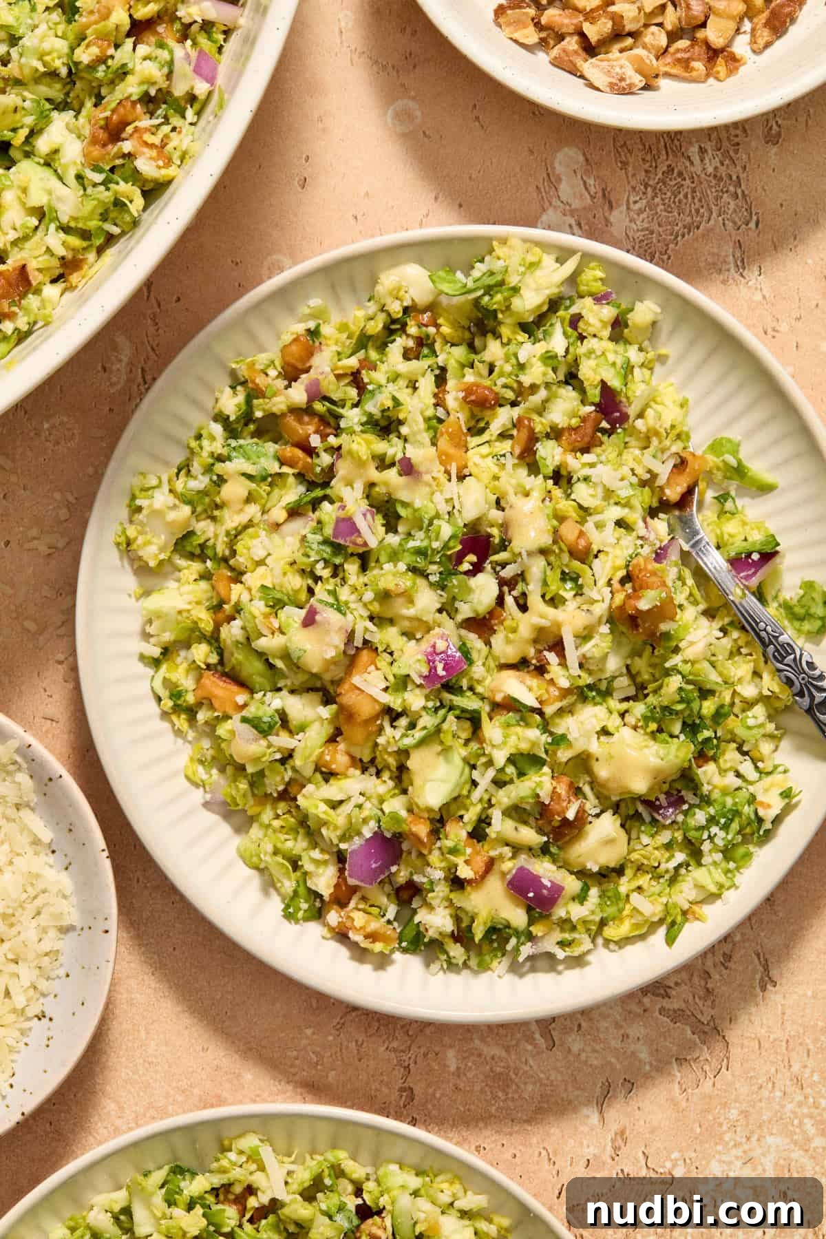 Crisp Shaved Brussels Sprout Salad with Lemon Parmesan Dressing 10 Plate with shaved brussels sprout salad with extra dijon dressing over top and fork scooping in.
