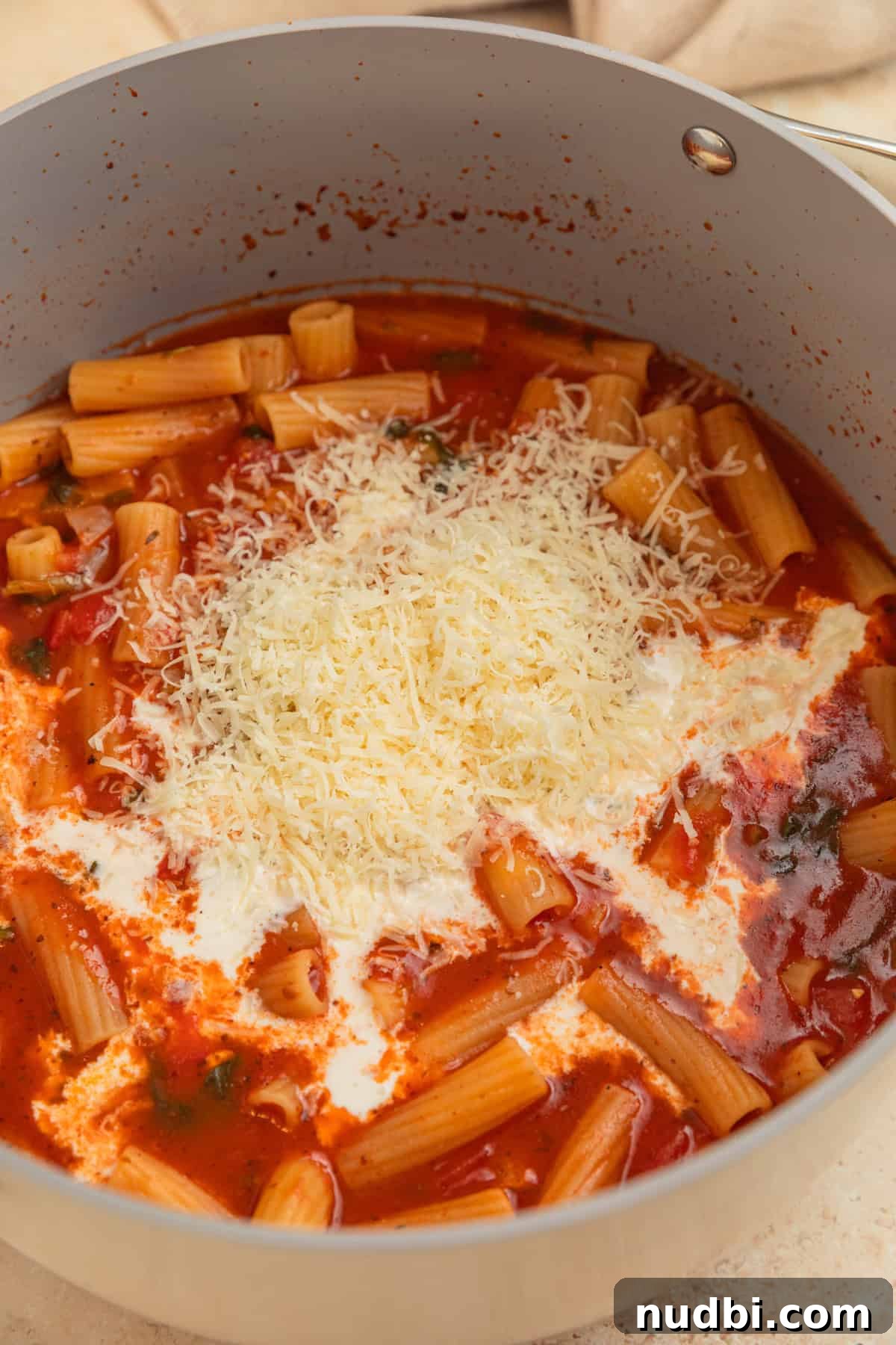 Creamy One-Pot Pasta Recipe for Quick Weeknight Meals 6 Cream and parmesan added to pot with pasta.