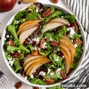 Warm Roasted Pear Salad with Goat Cheese and Candied Pecans 8 Roasted pear salad in white salad dish with pecans, goat cheese and more.