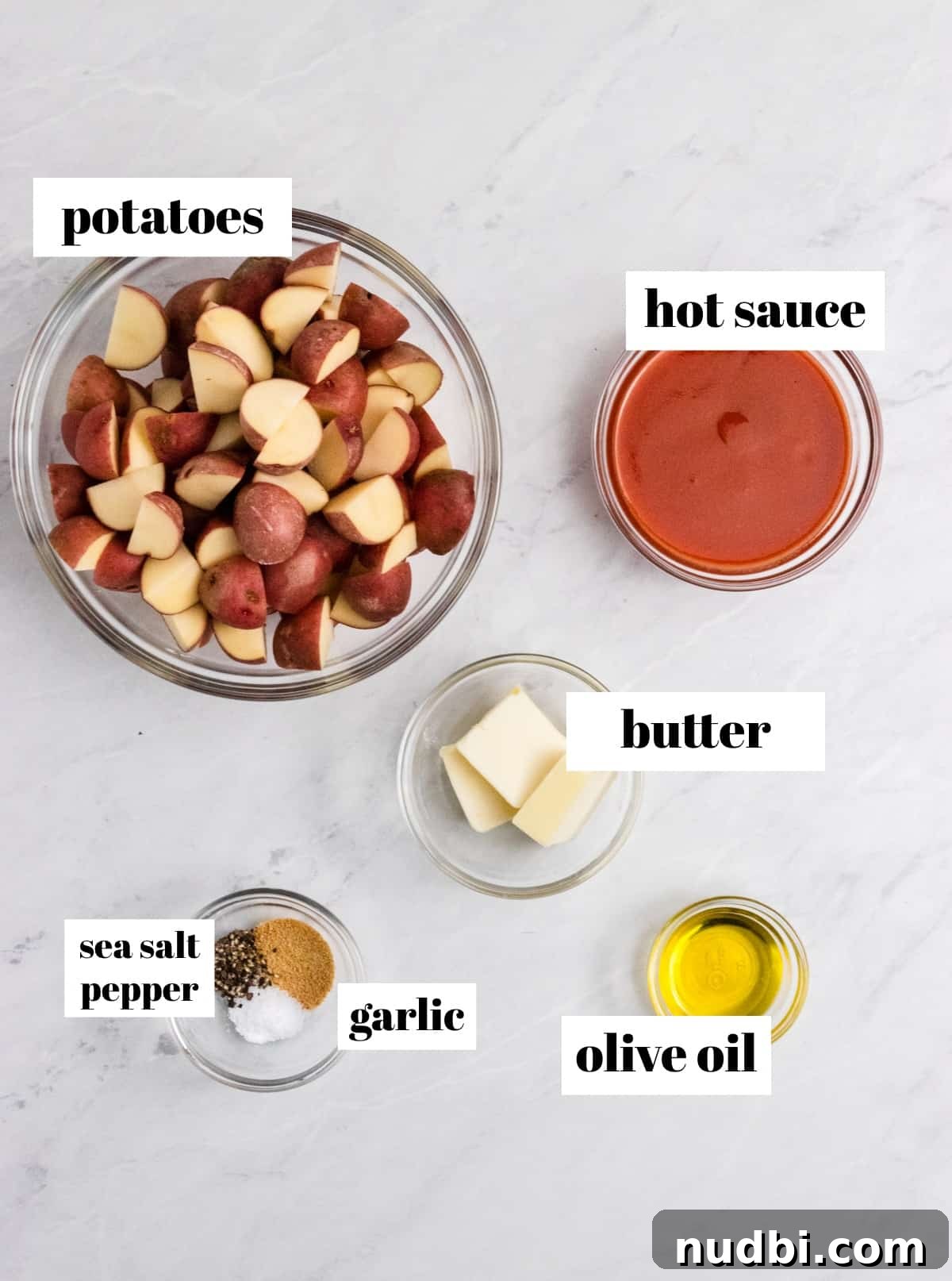 Crispy Buffalo-Style Air Fryer Baby Potatoes 3 Baby potatoes, hot sauce, butter and other ingredients on counter.