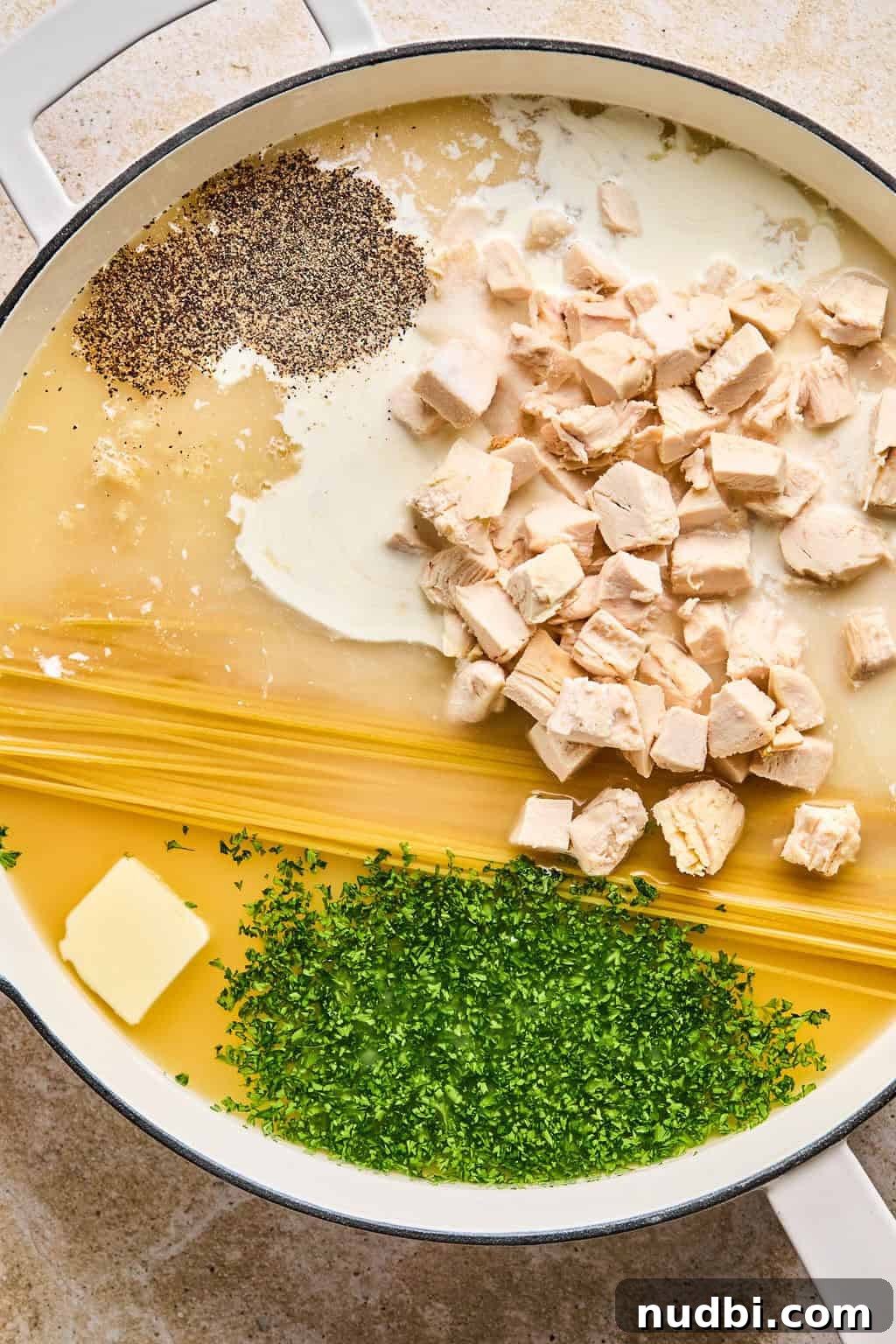 Creamy Chicken Alfredo Dinner Recipe in 30 Minutes 5 Pot with dried pasta, butter, chicken, parsley, cream, and spices.