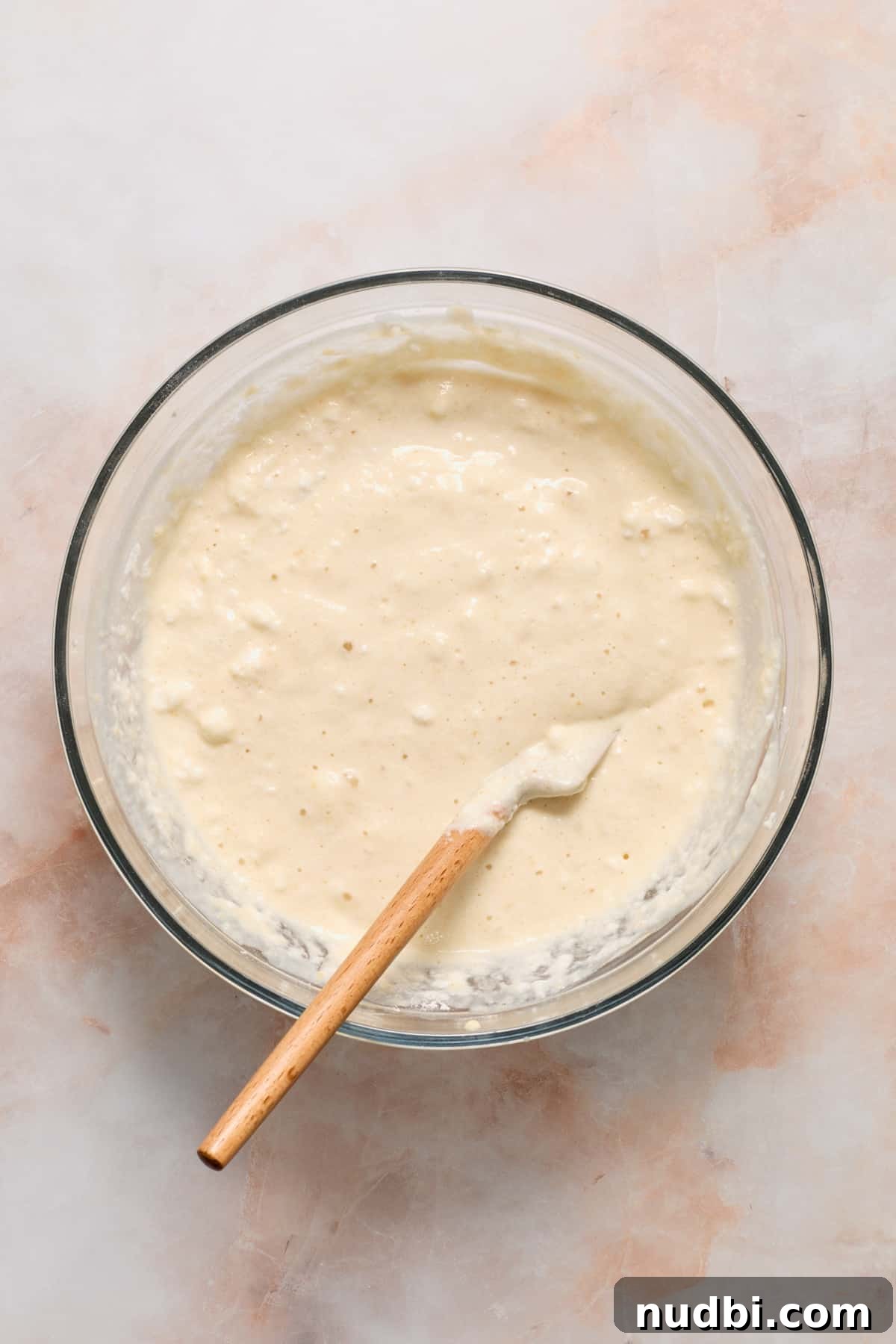 Pancake batter in mixing bowl with spatula.