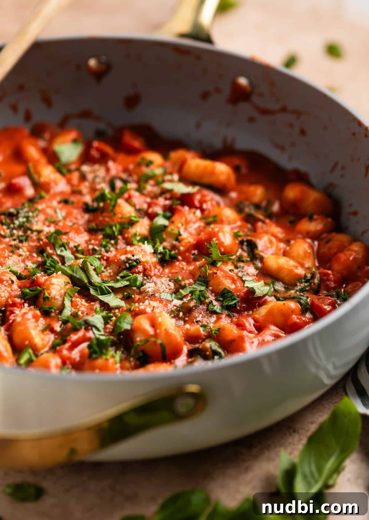 15-Minute Tomato Basil Gnocchi Recipe for Quick Weeknight Meals 2 Skillet with creamy tomato basil gnocchi topped with parmesan, basil and parsley.