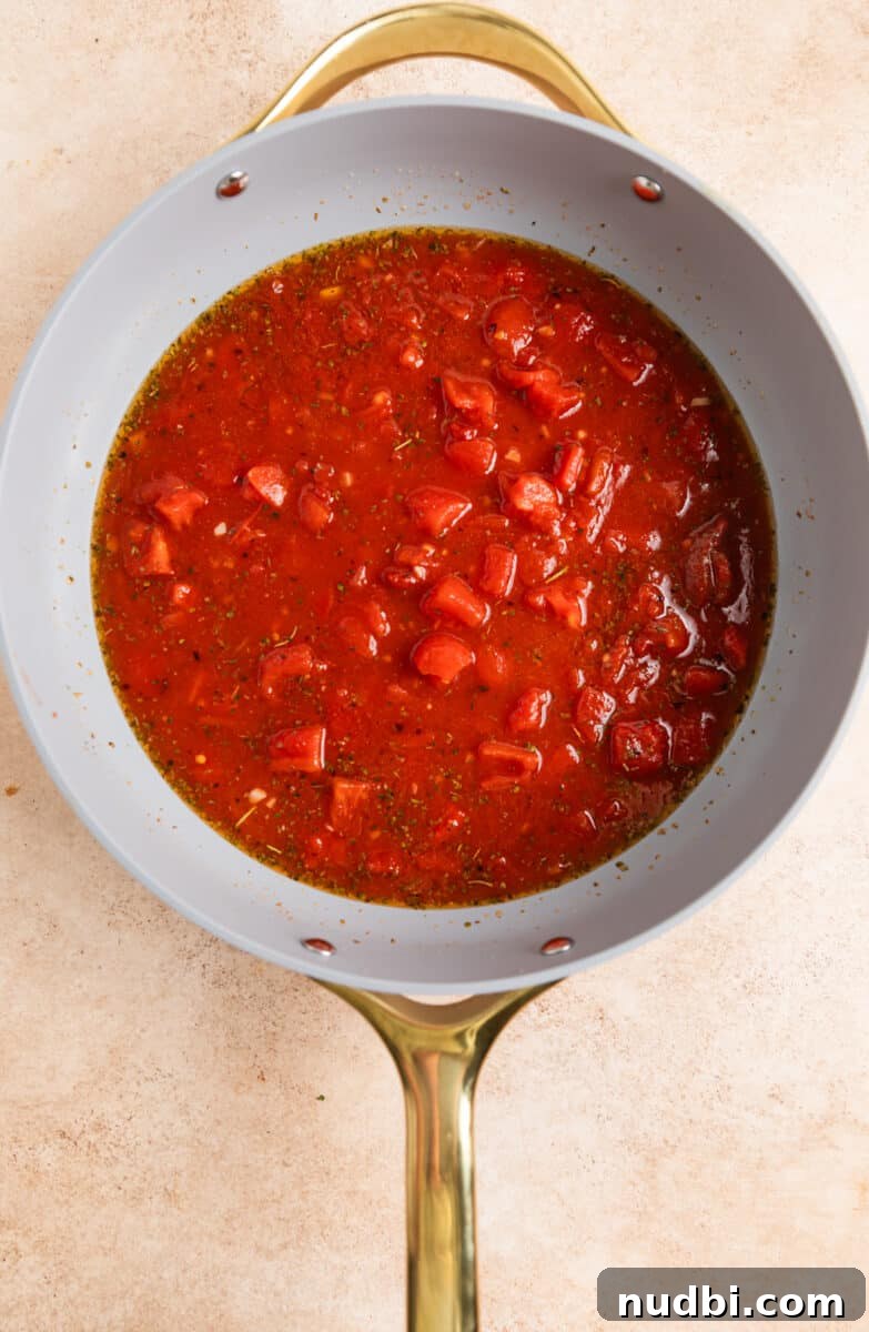 15-Minute Tomato Basil Gnocchi Recipe for Quick Weeknight Meals 4 Tomatoes, broth, garlic and seasoning in skillet.