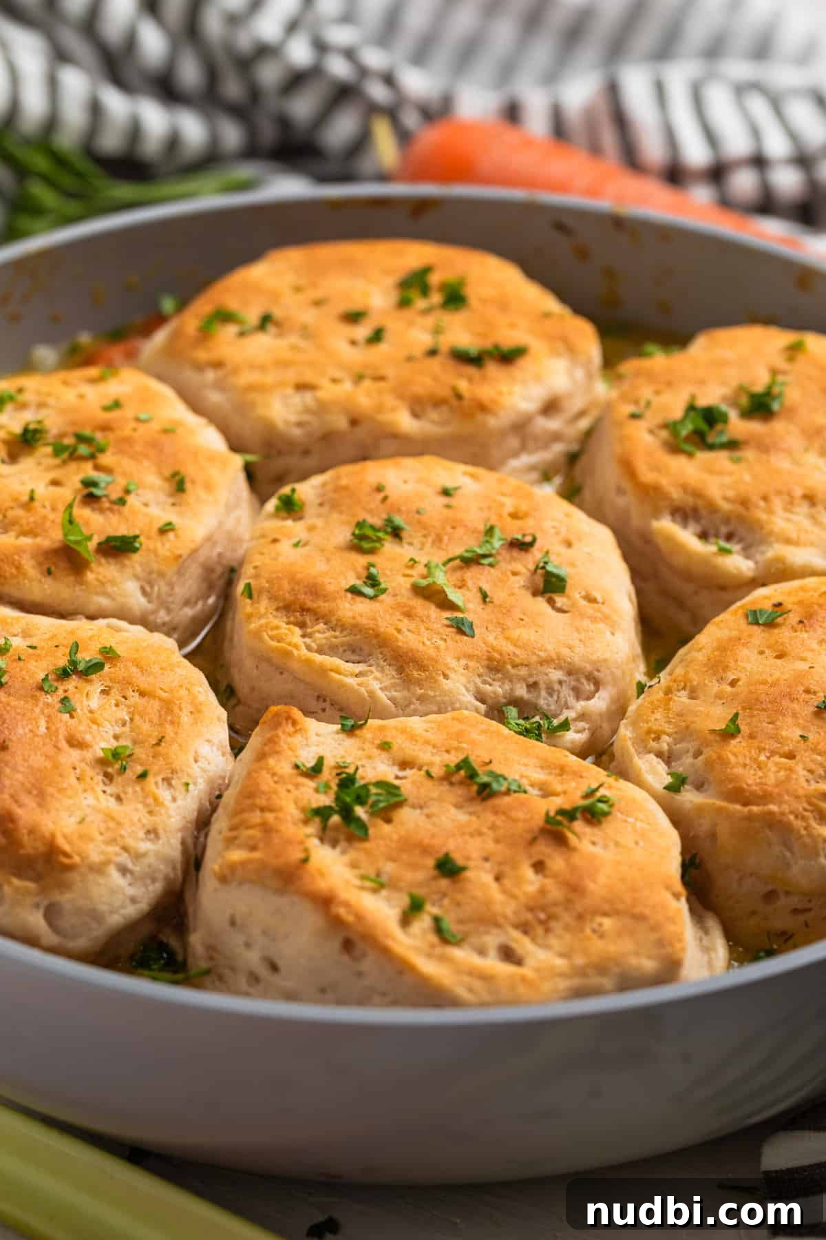 One-Pan Chicken and Biscuits Skillet Recipe 3 Chicken and biscuits in skillet topped with freshly chopped parsley.
