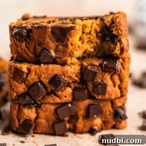 Stack of pumpkin banana bread with chocolate chips slices on top of each other.