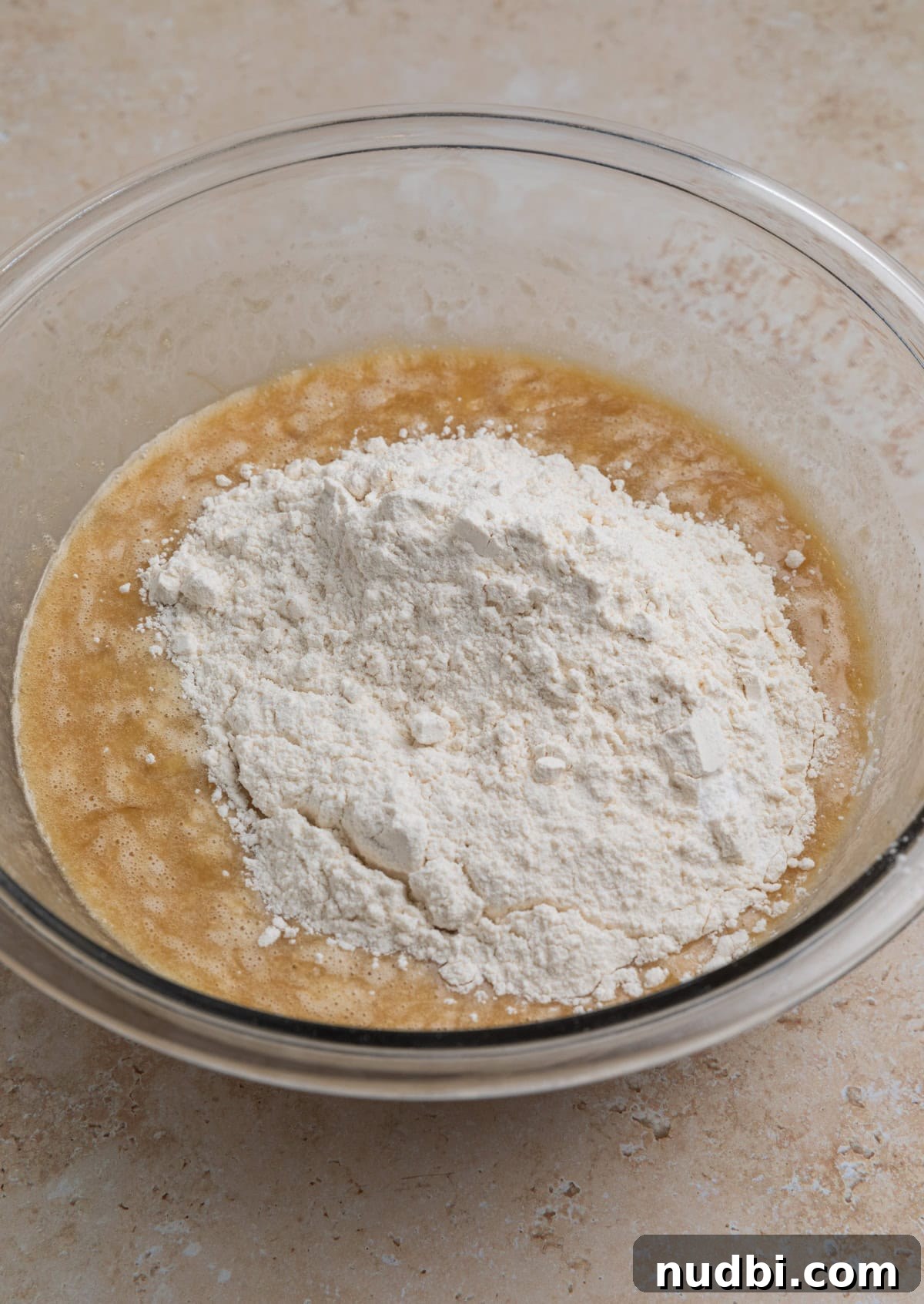 Moist Banana Blueberry Muffins with a Crunchy Streusel 7 Dry ingredients added to wet ingredients in mixing bowl.