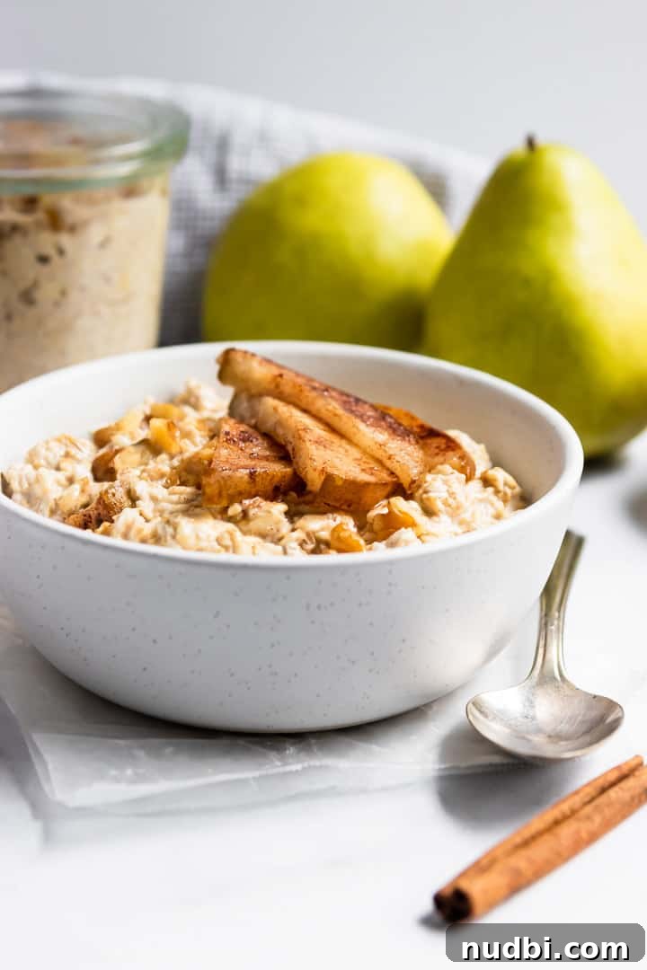 Spiced Pear & Walnut Overnight Oats for Cozy Mornings 4 Cinnamon pears on top of oatmeal in white bowl.