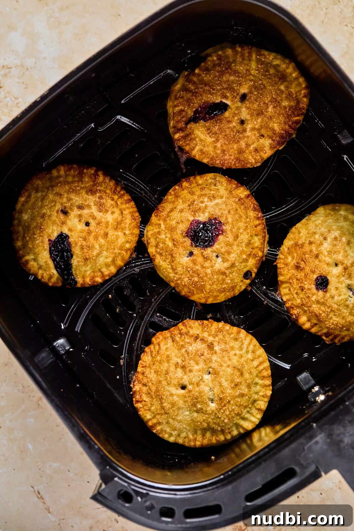 Air Fryer Blueberry Hand Pies Recipe 16 Cooked Air Fryer mini pies in air fryer basket.